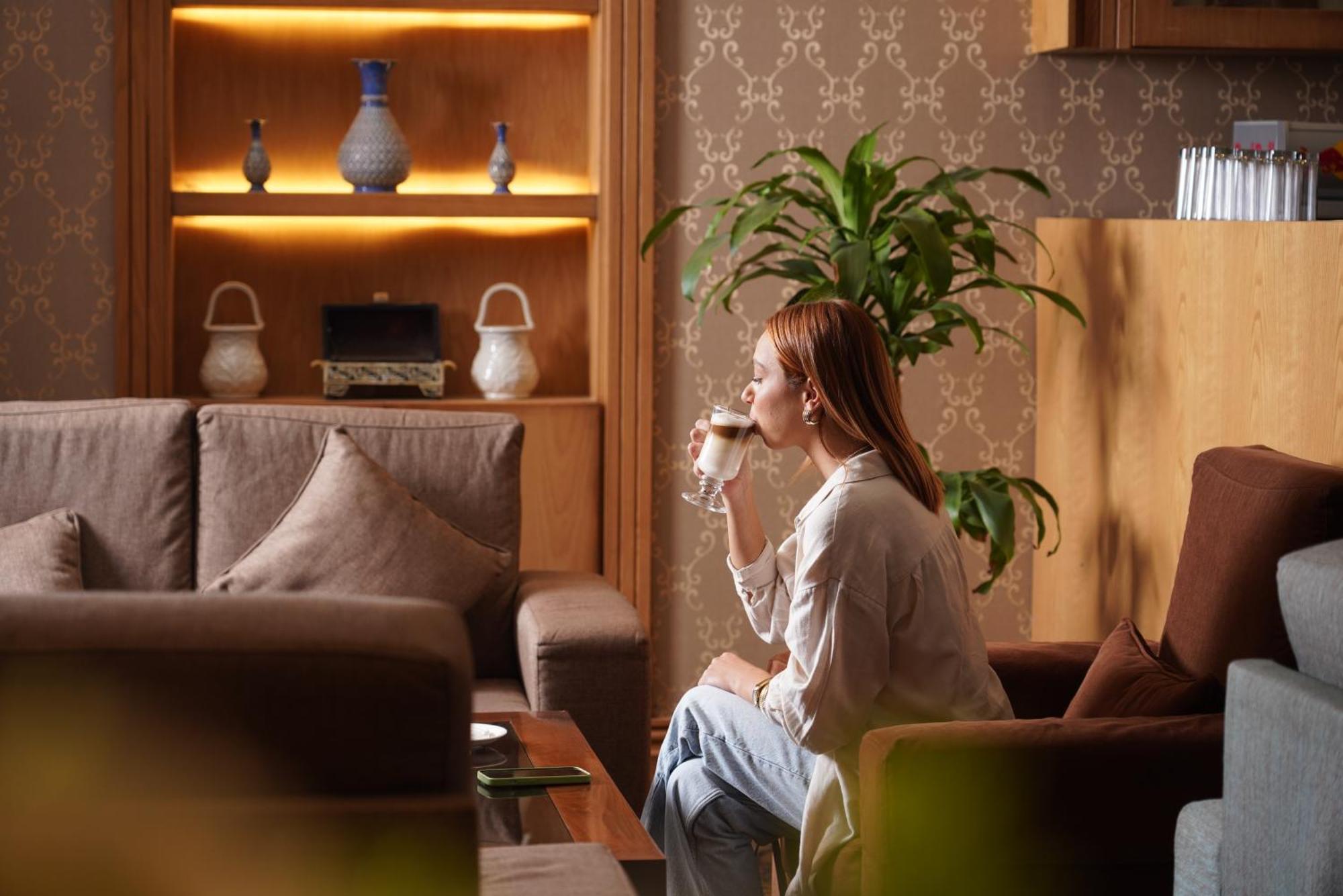 Thousand Nights Hotel Amman Exterior photo A woman drinking coffee